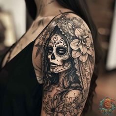 a woman's shoulder with a skull and flowers on it