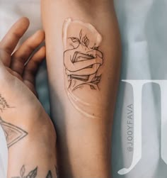 a woman's arm with tattoos on it and a glass vase in the shape of a rose