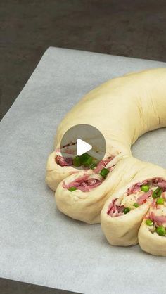 a doughnut shaped like a ring with meat and veggies in it on a piece of parchment paper