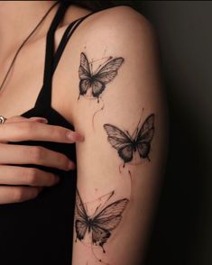 a woman's arm with three butterflies tattooed on the back of her left arm