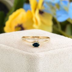 a close up of a ring on top of a white box with flowers in the background