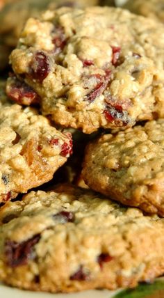 several oatmeal cookies stacked on top of each other with cranberries in the background