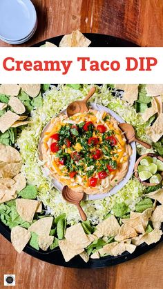 a platter filled with taco dip and tortilla chips on top of it