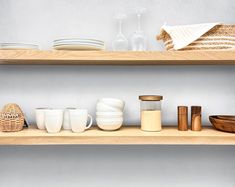 two wooden shelves filled with dishes and cups