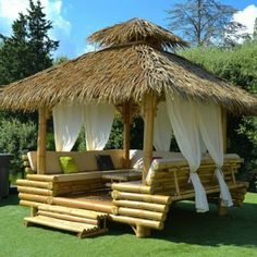 a wooden gazebo sitting on top of a lush green field