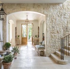 an entry way with stairs and potted plants