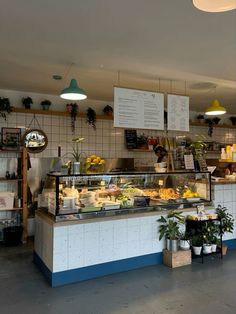 the inside of a restaurant with plants and food