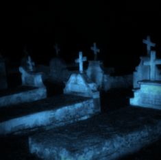 several headstones are lit up in the dark