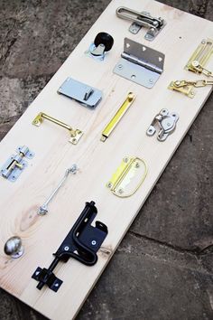 several different types of hardware on a wooden board with handles and latches attached to it