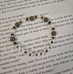 a book page with a bracelet made out of beads and letters that spell out love