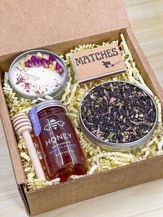 an open box filled with different types of teas and condiments on top of a wooden table