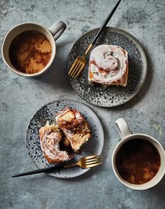 two plates topped with donuts next to cups of coffee