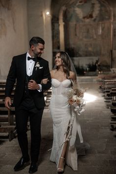 a bride and groom walking down the aisle at their wedding ceremony in an old church