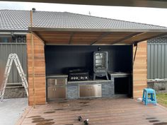 an outdoor bbq with grills and chairs