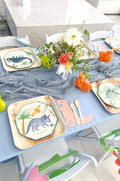 the table is set with dinosaur plates and napkins