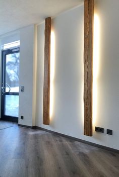 an empty room with wood floors and two large wooden beams on the wall above them