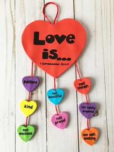 a colorful heart hanging from a string with words on it