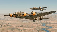 two planes flying in the air with camouflage paint