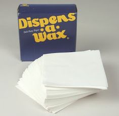 a box of dispensing wax on top of a stack of napkins