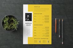 a yellow and white resume on top of a black table next to a potted plant