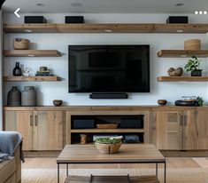 a living room filled with furniture and a flat screen tv mounted on a wall above a wooden coffee table