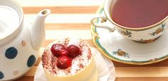 two desserts on plates next to a cup of tea