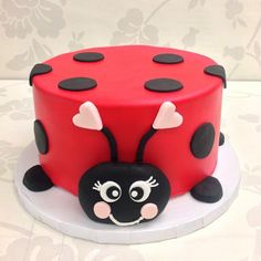 a red and black cake decorated with a ladybug