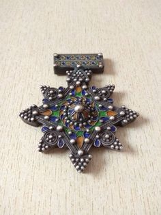 Beautiful traditional silver berber cross pendant, with nice quality enamel work, most likely handmade in Morocco (Tiznit) . This extremely well made vintage piece that tests silver. The enamel colors used are vivid and contrast wonderfully with the granulation work. Length : 9,2 cm (3,6 inches) Width : 7,6 cm (2,9 inches) Height : 1 cm (0,4 inches) Weight : 58 g Traditional Cross Jewelry For Collectors, Traditional Collectible Cross Jewelry, Silver Oxidized Cross Pendant Jewelry, Silver Bohemian Brooches For Collectors, Amazigh Necklace, Old Silver Coins, Berber Jewelry Morocco, Ornate Silver Enamel Brooches, Enamel Cross