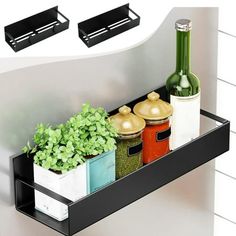 two black shelfs holding spices, herbs and other kitchen utensils in front of a sink