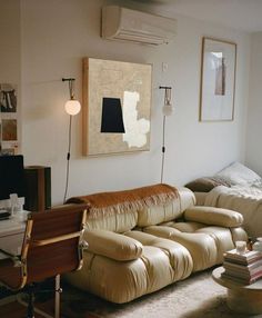 a living room filled with furniture and a painting on the wall