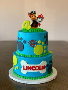 a birthday cake for a little boy with paw patrol characters on top and a name that says lincoln