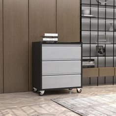 a black and white filing cabinet sitting in front of a wall with shelves on it