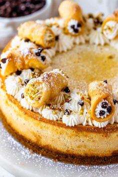 there is a cake with white frosting and toppings on the top, sitting on a plate