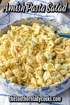 a bowl filled with pasta salad sitting on top of a blue and white table cloth