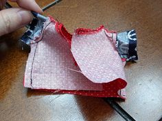 someone is cutting up the fabric on top of an origami piece with scissors