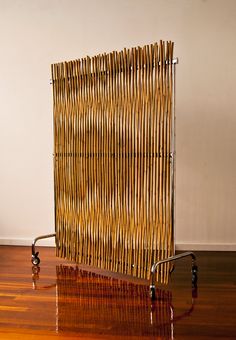 a bamboo screen sitting on top of a hard wood floor next to a metal rack