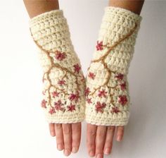 a pair of crocheted hand warmers with flowers on the wrist and fingers