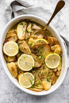 a white bowl filled with potatoes and lemon slices