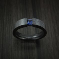 a black ring with a blue diamond in it