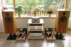 there are many speakers on the table in front of the window with potted plants