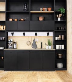 a kitchen with black cabinets and shelves filled with pots, pans and other cooking utensils