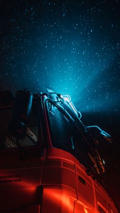 a car with its hood up in the dark under some bright lights and stars on the night sky