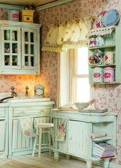 an old fashioned kitchen with pastel green cabinets and floral wallpaper on the walls