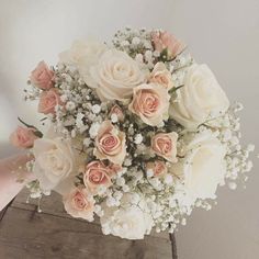 a bouquet of flowers sitting on top of a wooden box with baby's breath