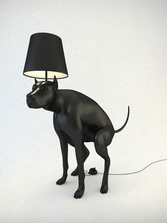 a black dog standing next to a lamp on top of a white floor with a light on it's head