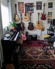 a room filled with guitars hanging on the wall and a piano in front of it