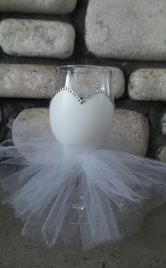 a wine glass with a white heart on it and a tulle around the bottom