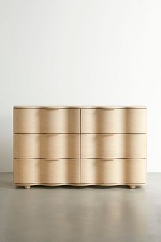 a large wooden dresser sitting on top of a hard wood floor next to a white wall