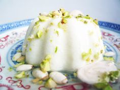 a cake with pistachio topping on a blue and white plate