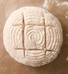 an uncooked ball of bread sitting on top of a piece of wax paper